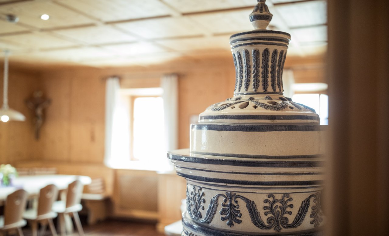 Traditionelle Stube im Hotel Masatsch mit weiß-blauem Kachelofen im Vordergrund