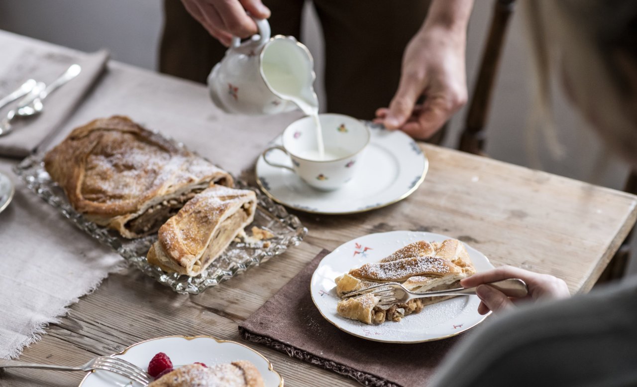 Set wooden table at Masatsch restaurant with apple strudel and cup