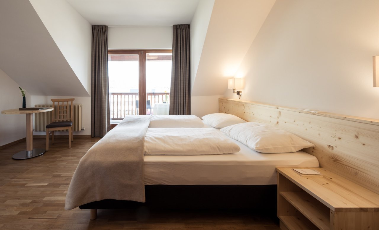 Helles Zimmer im Hotel Masatsch mit Holzboden, Doppelbett und Balkon