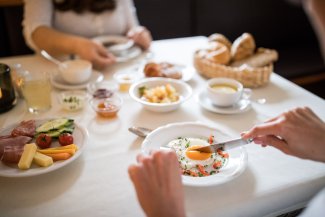 Frühstückssetting im Restaurant Masatsch mit Tee, Obst und Croissants