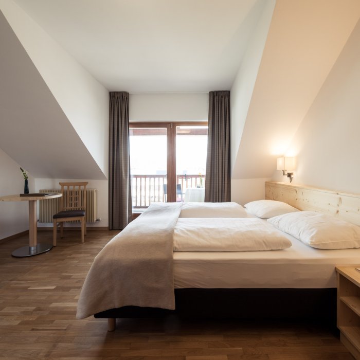 Gemütliches Zimmer im Hotel Masatsch mit Holzboden und Doppelbett