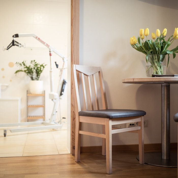 Gemütliches Hotelzimmer im Masatsch mit Holzstuhl und Blumenstrauß
