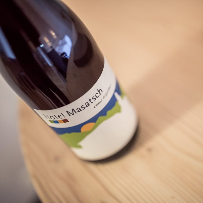 Flasche mit buntem Etikett und Hotel-Masatsch-Logo