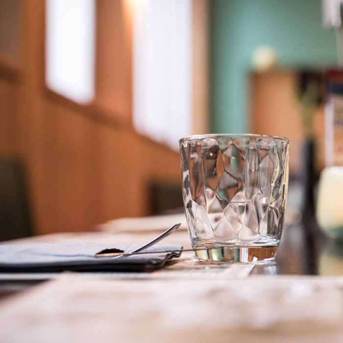 Gedeckter Tisch mit Glas, Serviette und stilvollem Detail im Restaurant Masatsch